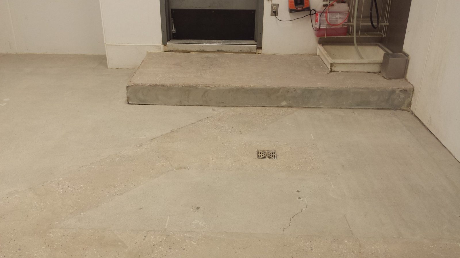 Bare concrete slab after old floor glue was ground away